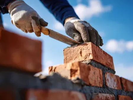 Mason laying masonry in mortar for a Burbank garden wall
